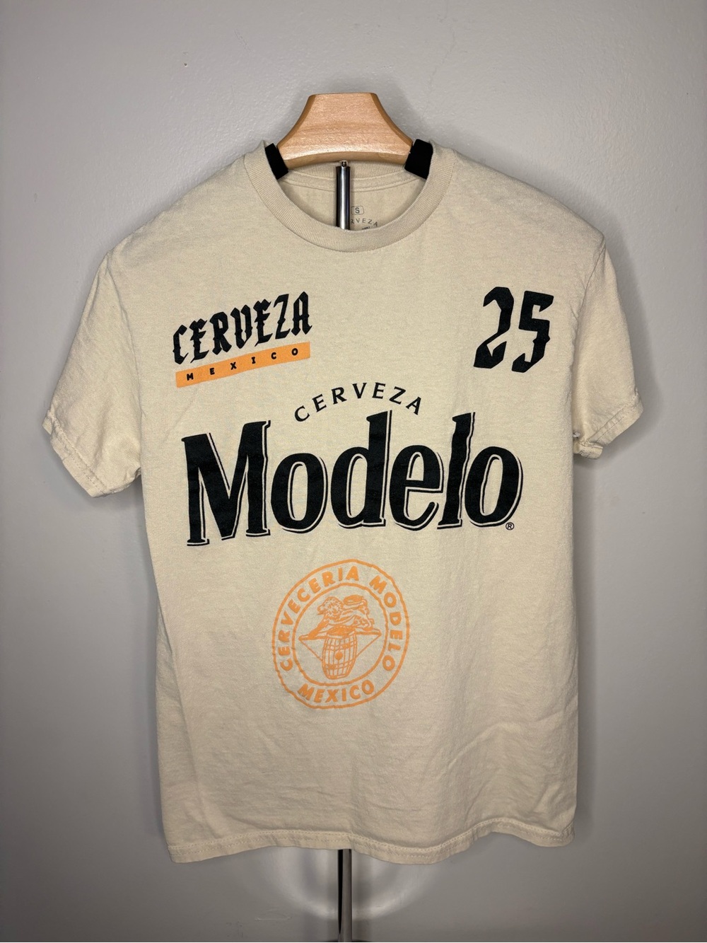 ModelCo Cream Graphic 'Modelo' Logo Tee with Black & Orange Accents